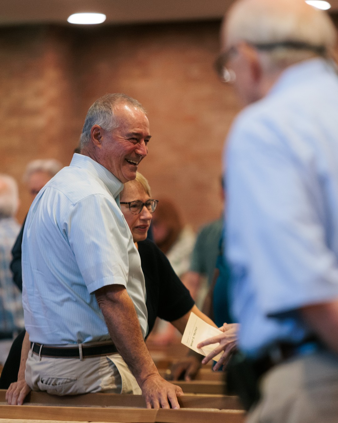 Church members sharing a smile in the pews at Nashville First